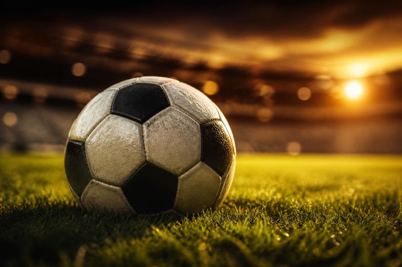 A football on the pitch at sunset